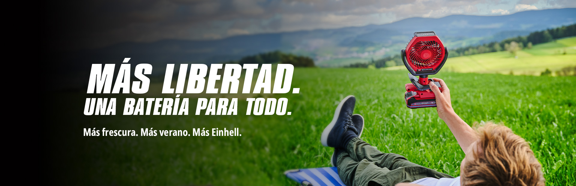 Imagen de un hombre tumbado en la hierba con un abanico en la mano y, a la izquierda, el texto. "MÁS LIBERTAD. UNA BATERÁ PARA TODO. Más frescura. Más verano. Más Einhell."