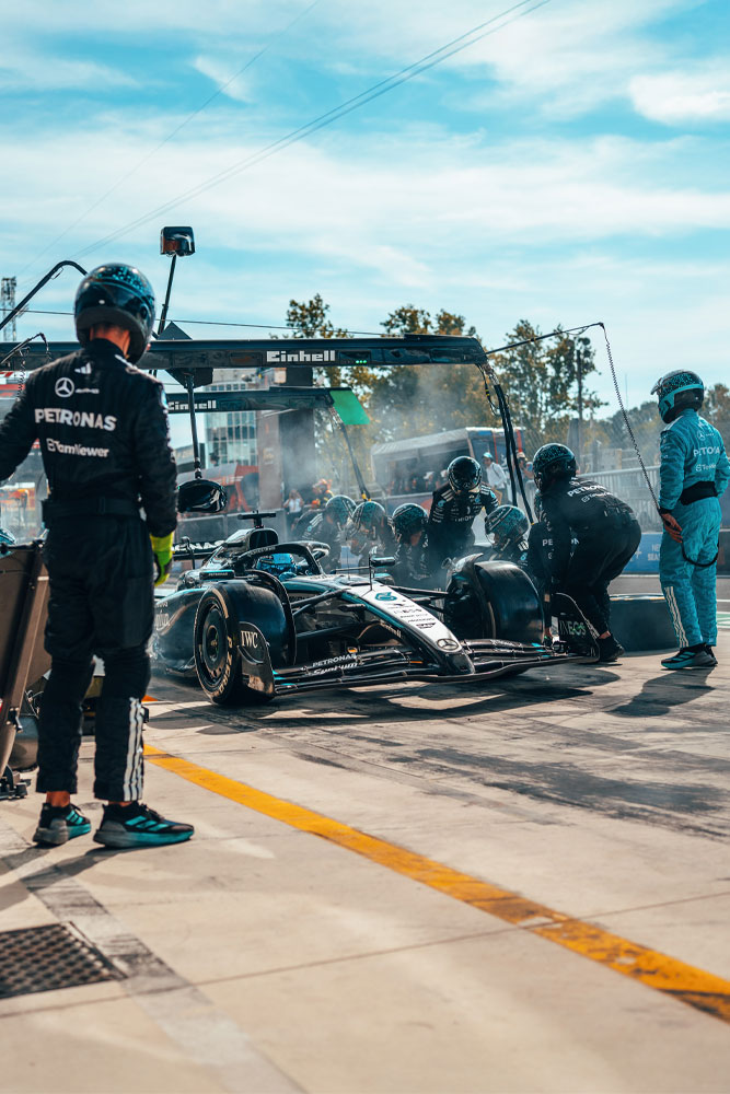 Una intensa detención en boxes para el equipo Mercedes-AMG PETRONAS Formula One. El equipo está en plena acción, cambiando neumáticos y revisando el auto bajo la estructura con el logo de Einhell.