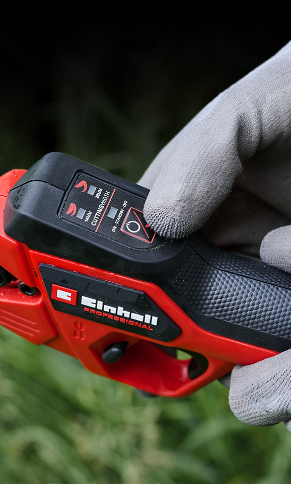 Primer plano de una herramienta Einhell inalámbrica con un usuario ajustando su configuración.