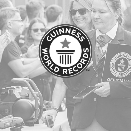 Imagen en blanco y negro: El logo de Guinness World Records sobre una foto del evento que muestra herramientas Einhell.