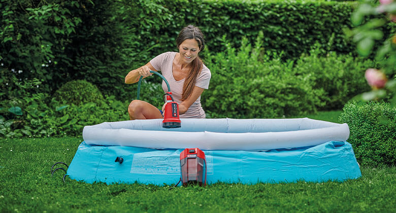 woman using a submersible clear water pump in a pool