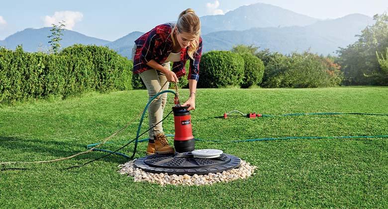 woman with a clear water pump in a garden